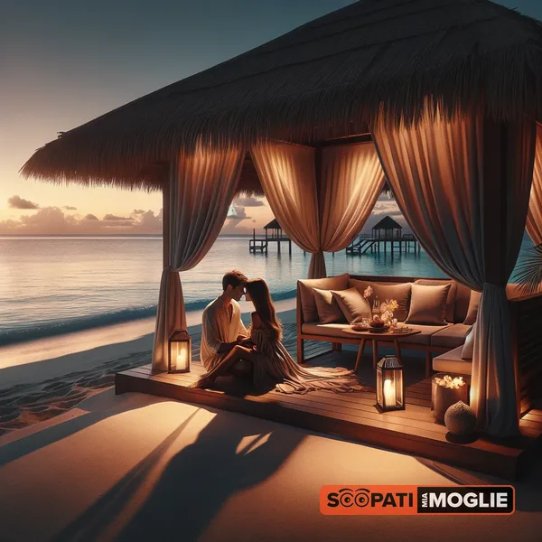 Una coppia si abbraccia dentro un gazebo sulla spiaggia illuminato da lanterne al tramonto.